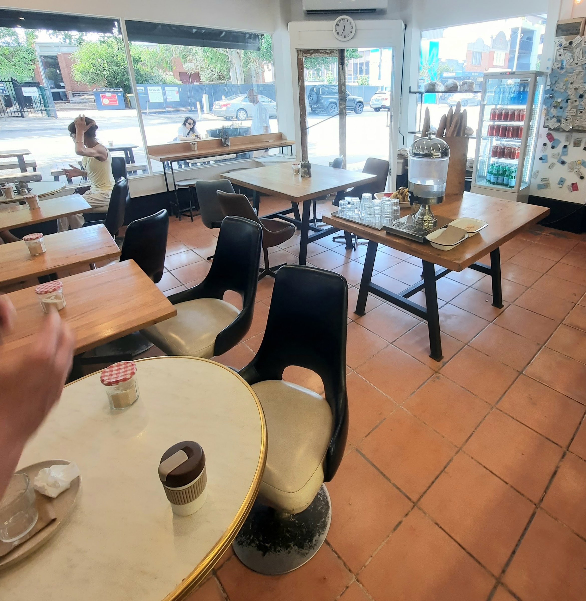 Tables by the big corner windows inside the cafe